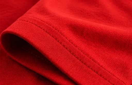 Detalhe visual da manga vermelha e da costura da camiseta.